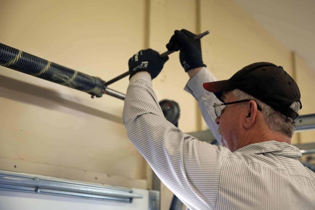 A man is repairing the garage door Spring who is available Garage door repair near me